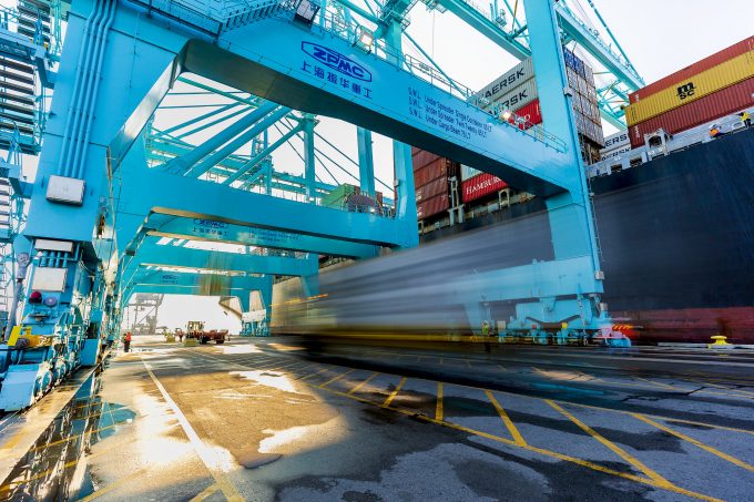 A blurred image of a container being taken off a ship