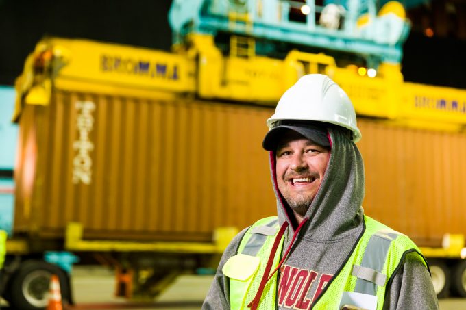 A dock worker standing in front of a container