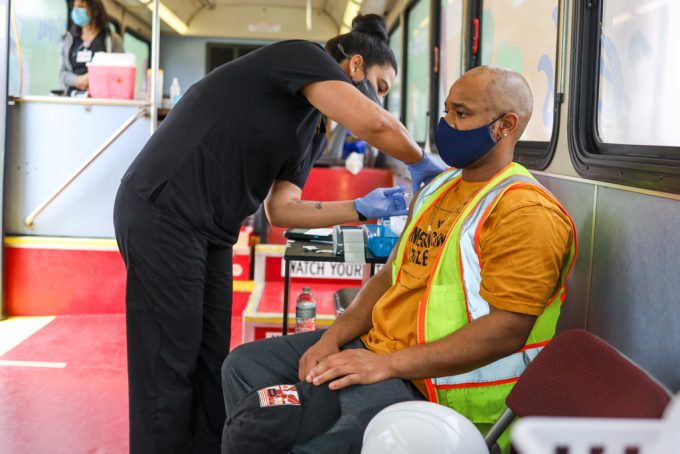 A port worker receives a covid-19 vaccine