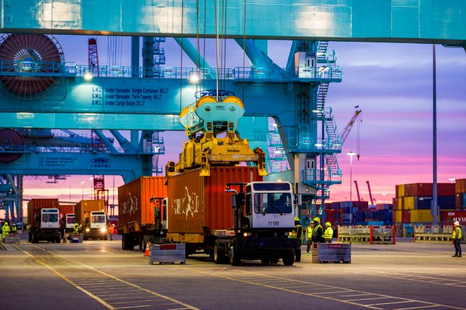 A container is being lifted off of a ship.