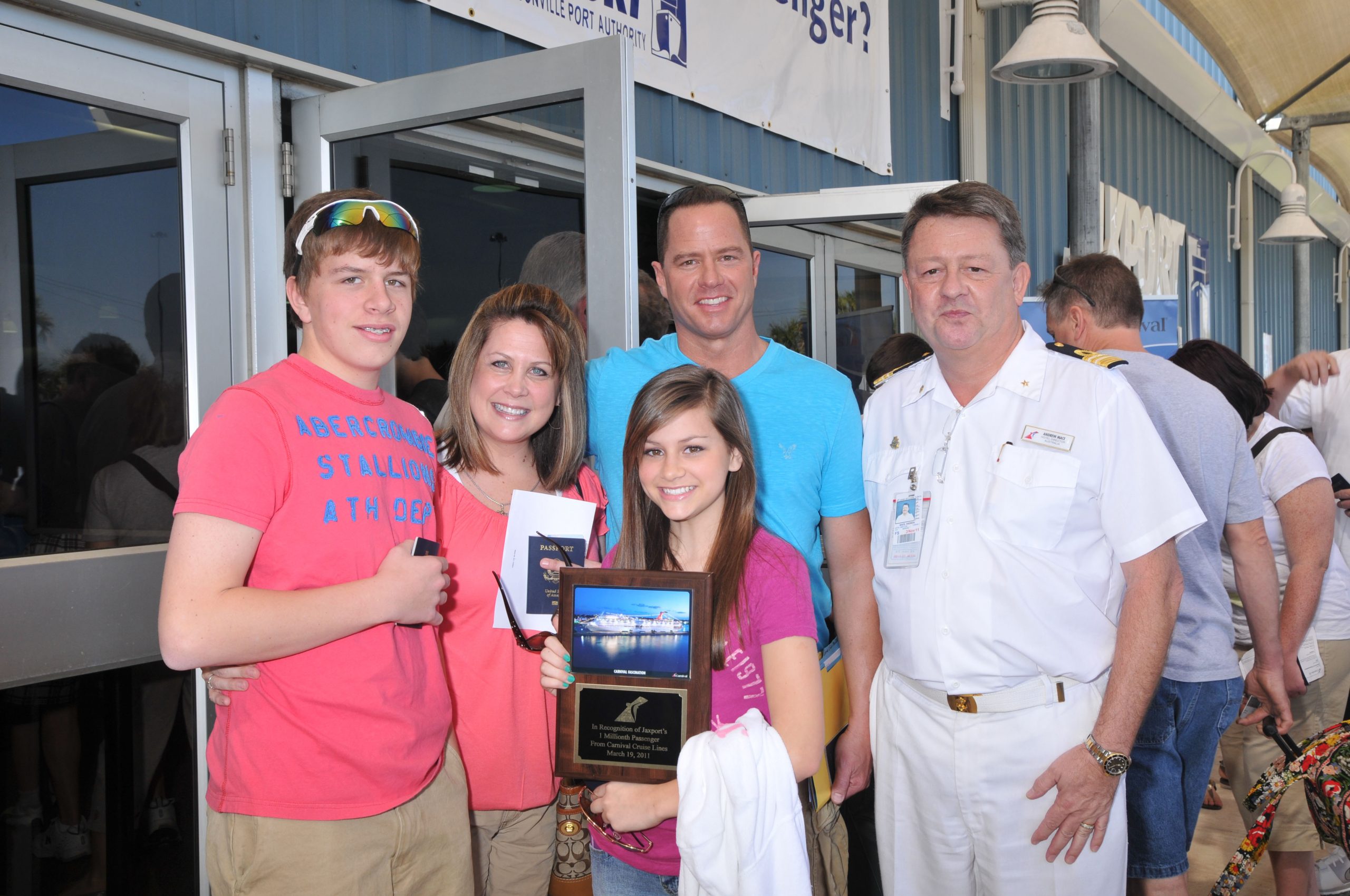 Cruise passengers pose with ceremonial plaque